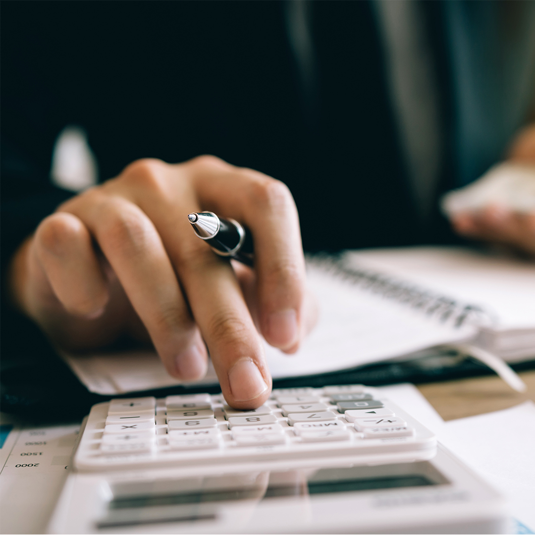 Office worker using a calculator at their desk